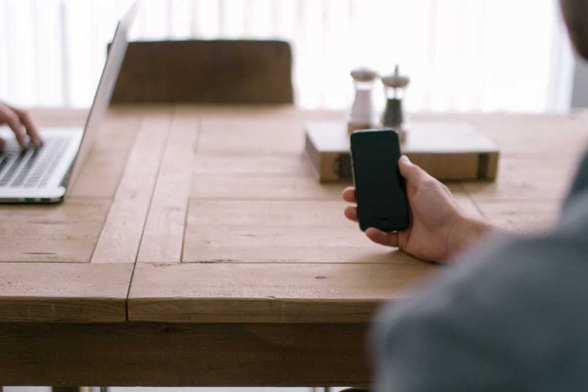Hand holding a smartphone over an office table